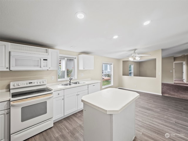 kitchen with ceiling fan, white cabinets, sink, white appliances, and a kitchen island