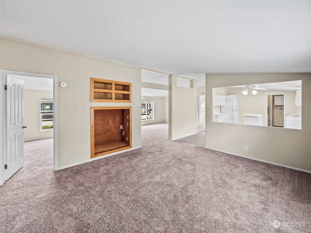 interior space featuring washer / clothes dryer, lofted ceiling, and ceiling fan