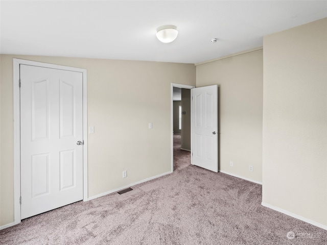 carpeted spare room with vaulted ceiling