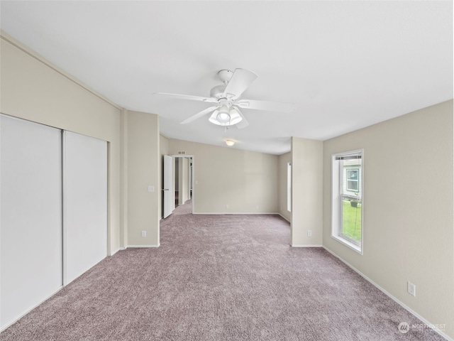 unfurnished bedroom featuring ceiling fan, a closet, and carpet