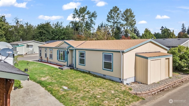 view of front facade with a front yard and a storage shed