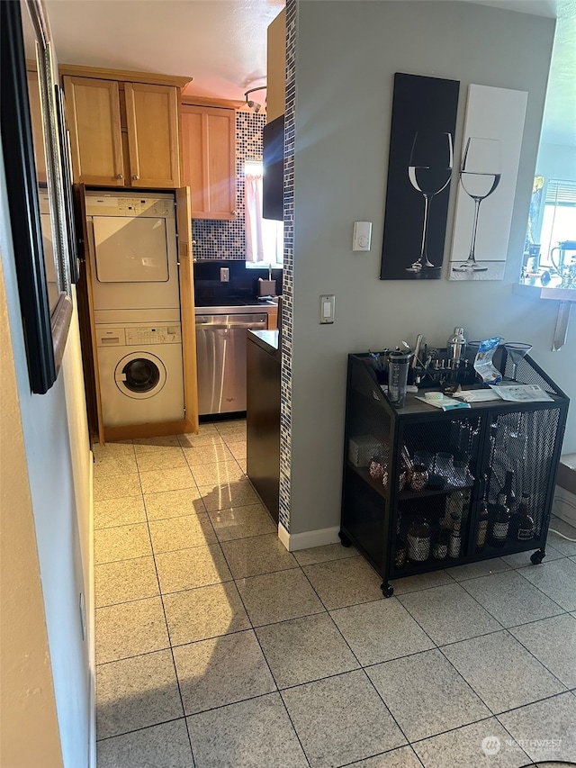 kitchen with appliances with stainless steel finishes and stacked washer and clothes dryer