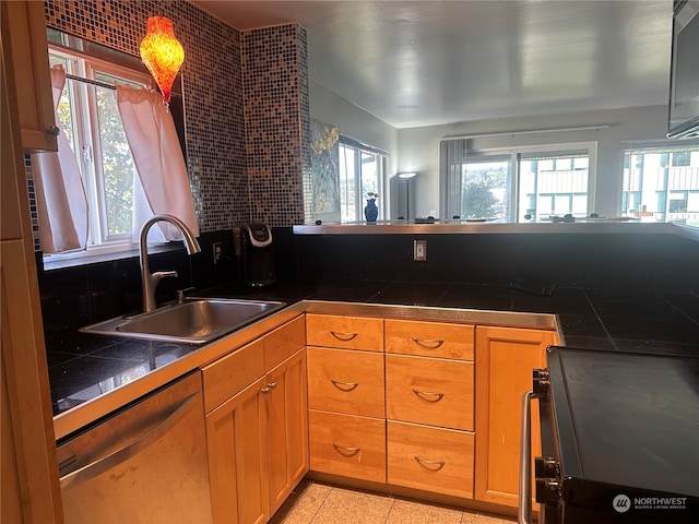 kitchen with black range oven, stainless steel dishwasher, sink, and light tile patterned floors