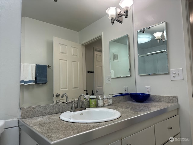 bathroom featuring vanity and a shower with shower door