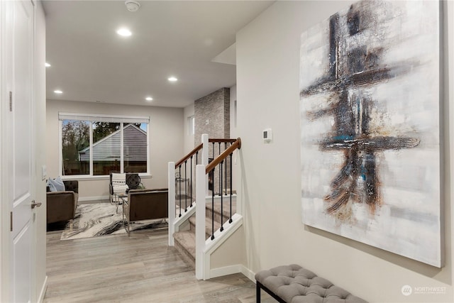 interior space with light wood-type flooring, baseboards, recessed lighting, and stairs