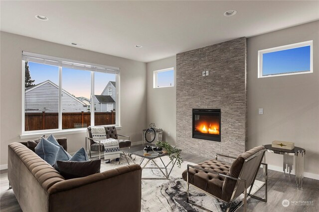 living room with a fireplace, wood finished floors, baseboards, and recessed lighting