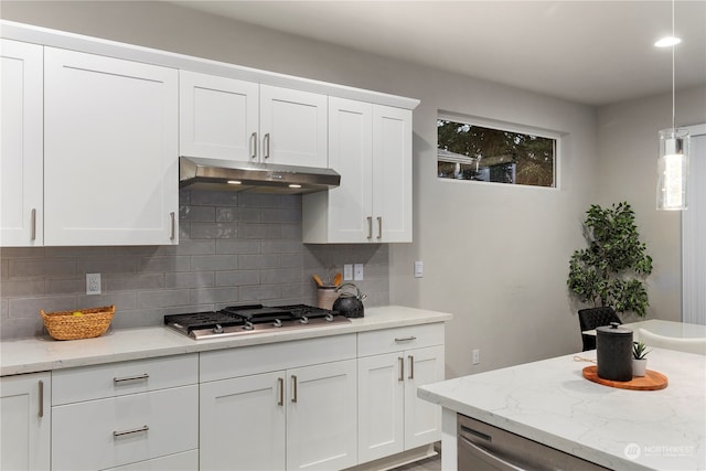 kitchen featuring hanging light fixtures, stainless steel gas cooktop, light stone countertops, and white cabinetry