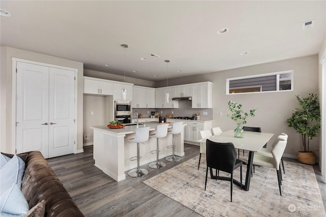 dining area featuring recessed lighting, wood finished floors, visible vents, and baseboards