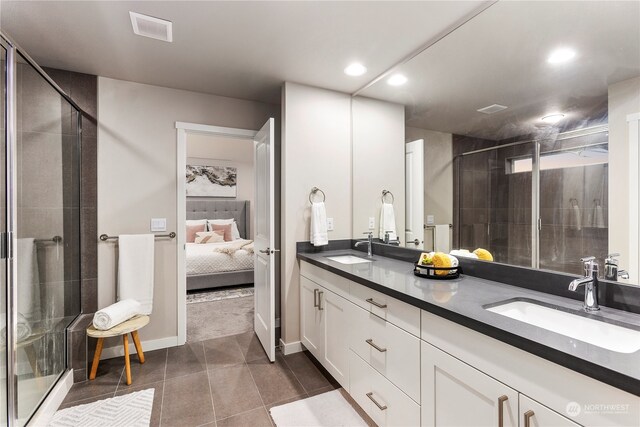 bathroom with tile patterned flooring, vanity, and walk in shower