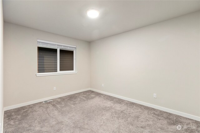 spare room featuring light colored carpet