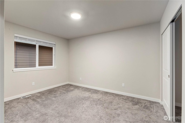 unfurnished bedroom featuring baseboards, a closet, visible vents, and carpet