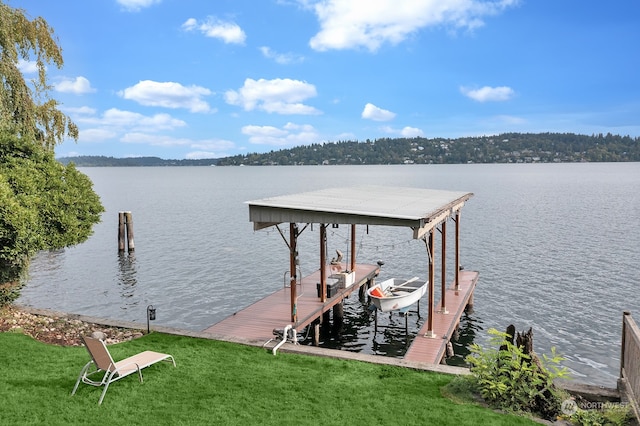 dock area featuring a water view and a lawn