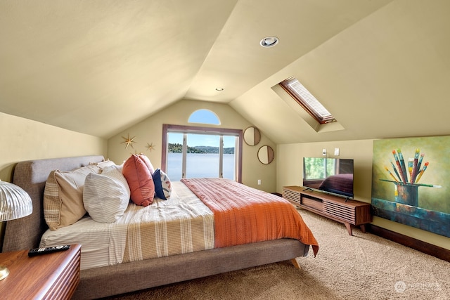 carpeted bedroom with access to exterior, vaulted ceiling with skylight, and multiple windows