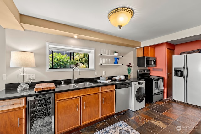 kitchen with washer / dryer, beverage cooler, stainless steel appliances, and sink