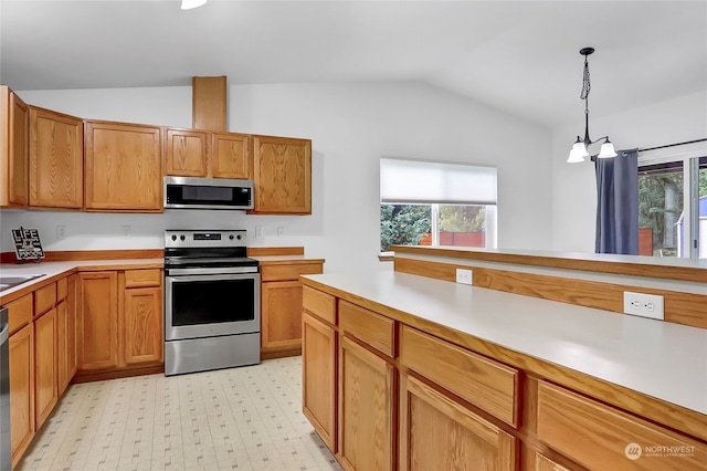 kitchen featuring pendant lighting, lofted ceiling, a healthy amount of sunlight, and stainless steel appliances