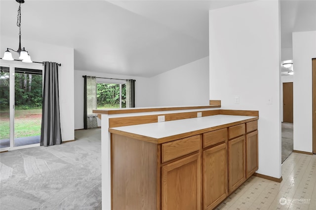 kitchen featuring light colored carpet, hanging light fixtures, and kitchen peninsula