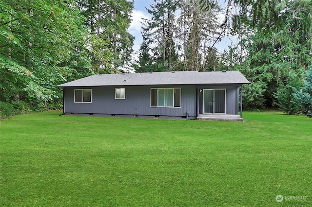 rear view of property featuring a lawn