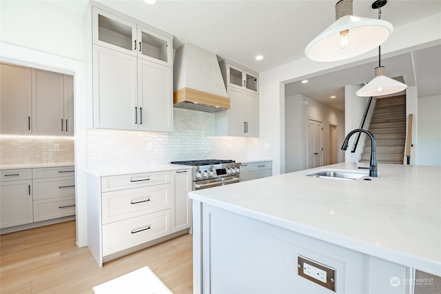 kitchen with hanging light fixtures, custom exhaust hood, and white cabinetry