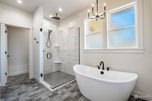 bathroom featuring separate shower and tub, a chandelier, and a healthy amount of sunlight