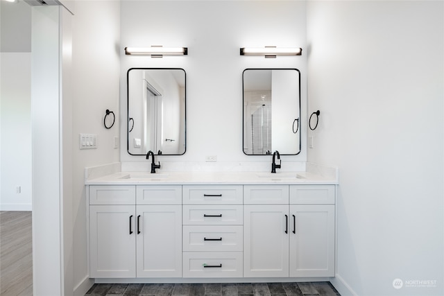 bathroom featuring wood-type flooring, walk in shower, and vanity