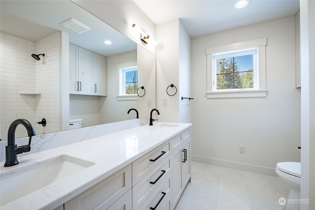 bathroom with vanity, toilet, a healthy amount of sunlight, and tile patterned flooring