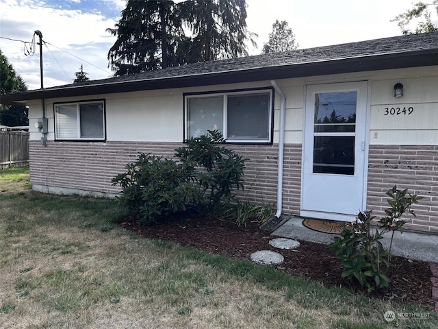 property entrance with a lawn