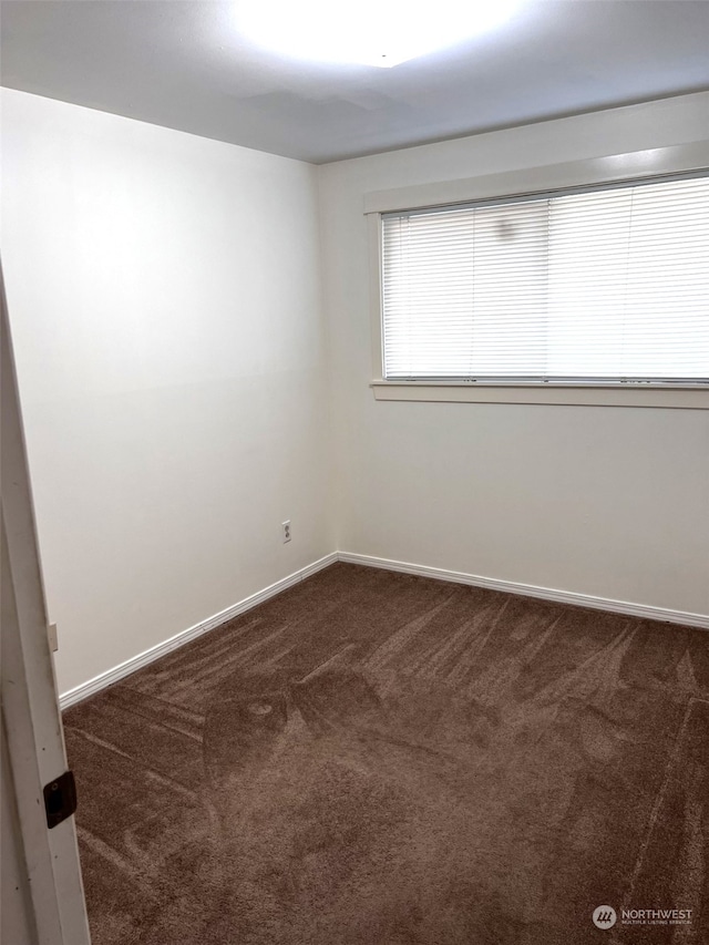 unfurnished room with dark carpet