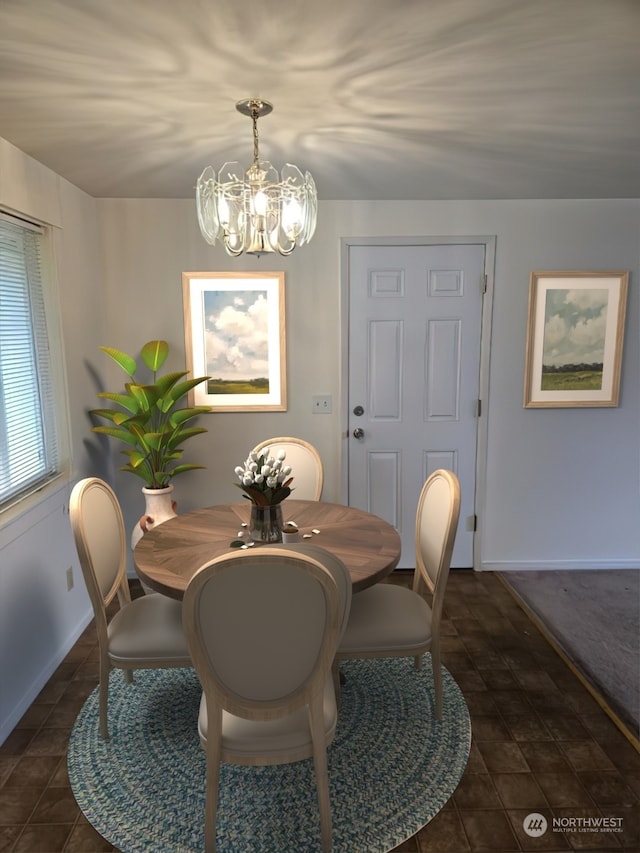 dining area with dark tile patterned floors and a notable chandelier