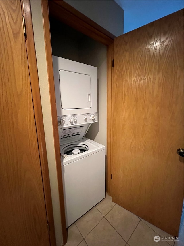 washroom with stacked washer and clothes dryer and light tile patterned floors