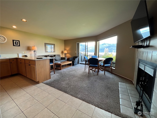 kitchen featuring a fireplace, light carpet, and kitchen peninsula