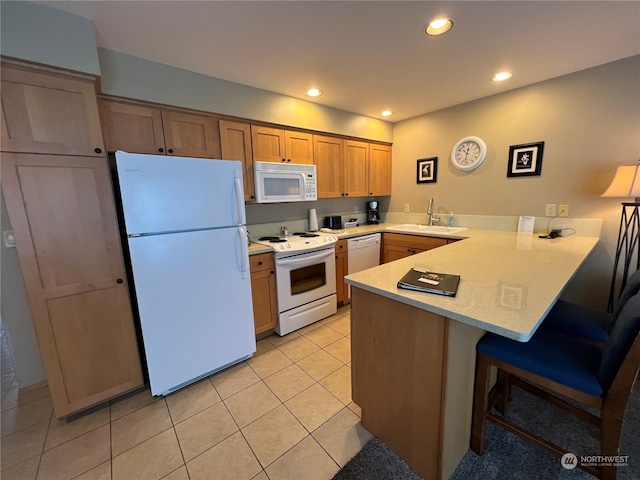 kitchen with white appliances, kitchen peninsula, sink, a breakfast bar, and light tile patterned flooring