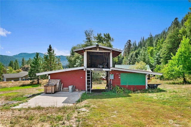 rear view of property with a lawn and a mountain view