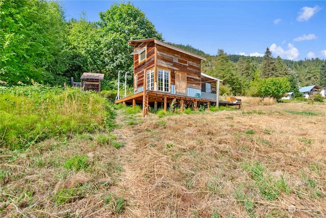 rear view of house with an outdoor structure and a deck