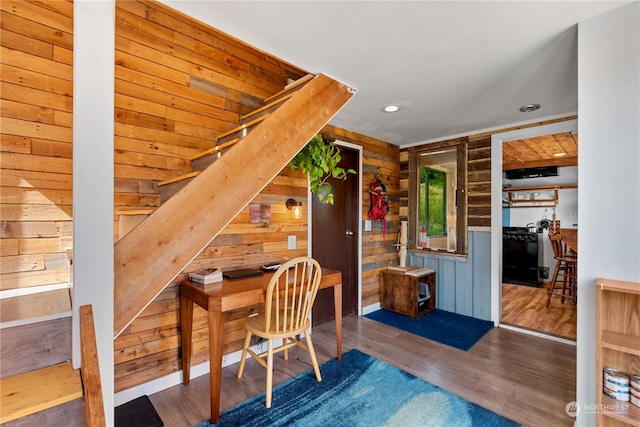 office featuring hardwood / wood-style flooring and wooden walls