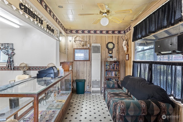 interior space with ceiling fan and wooden walls