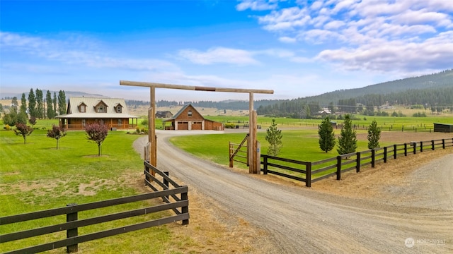 surrounding community featuring a mountain view, a rural view, an outdoor structure, and a lawn