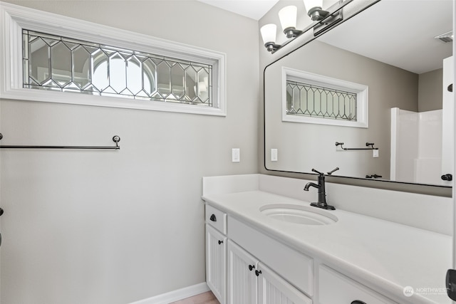 bathroom featuring a shower and vanity