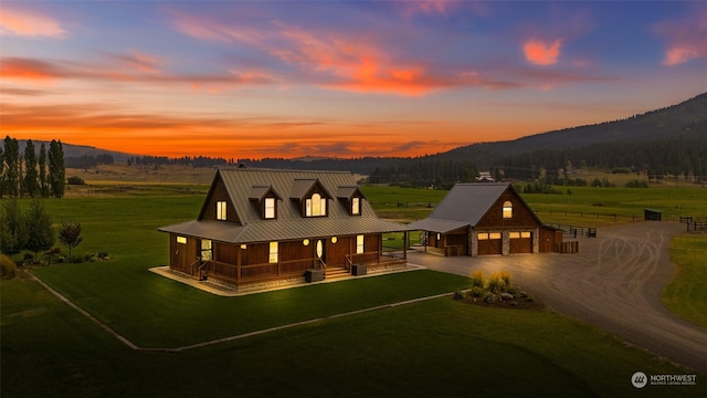 view of front facade with a mountain view, a garage, an outdoor structure, and covered porch