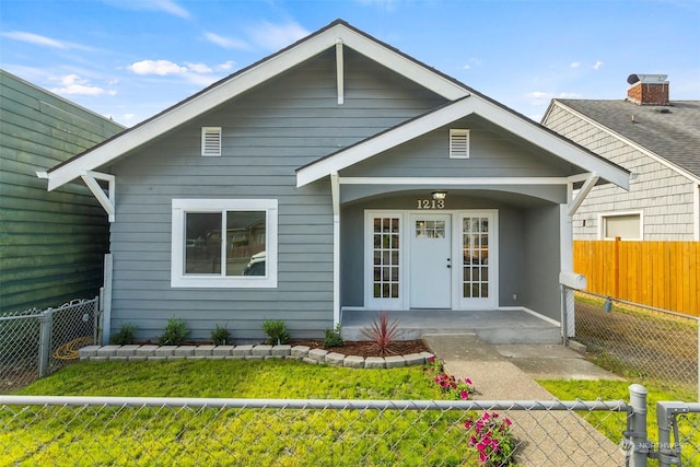 view of front of house with a front yard and french doors