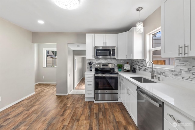 kitchen featuring a sink, stainless steel appliances, backsplash, and light countertops