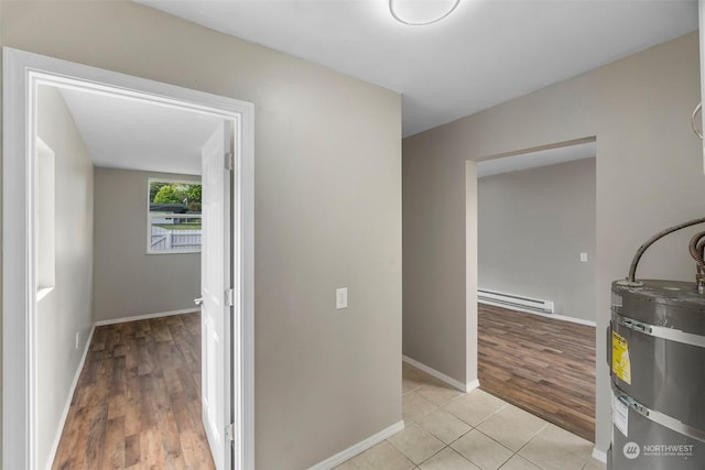 hall with strapped water heater, light tile patterned floors, baseboards, and baseboard heating