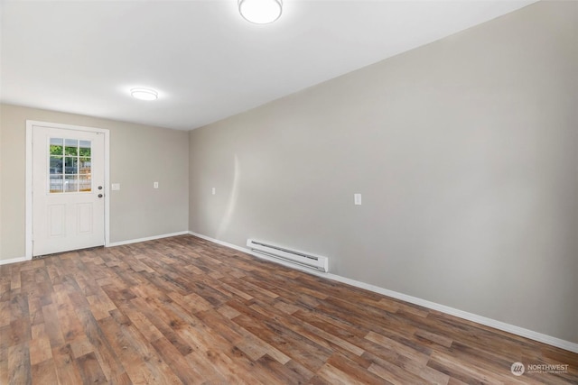 unfurnished room with wood finished floors, baseboards, and a baseboard radiator