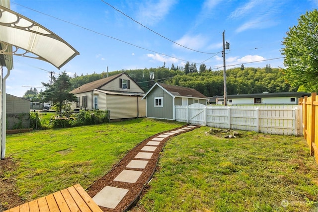 view of yard featuring a gate, an outdoor structure, and fence