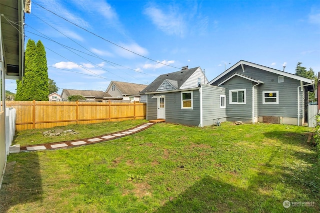 back of property featuring a yard and fence