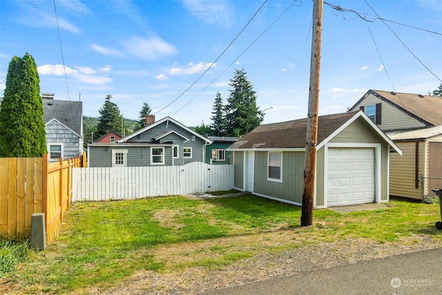 view of front of property featuring an outbuilding, a gate, fence, and driveway