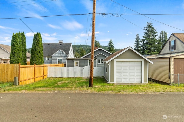 view of front of home featuring an outdoor structure, fence, and a garage