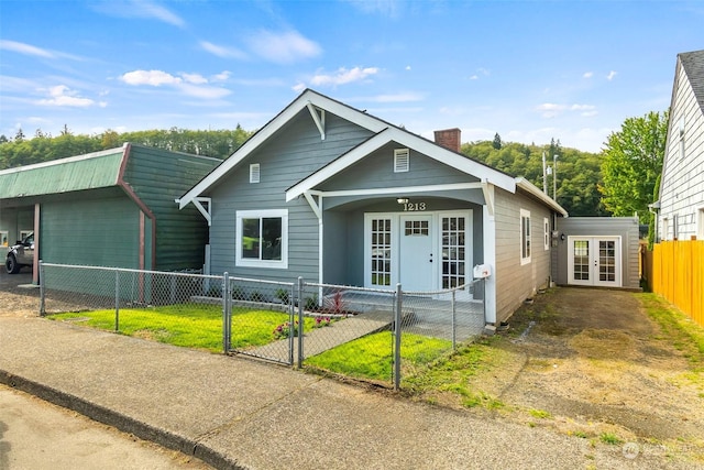 view of front of home featuring a chimney, french doors, fence private yard, and a gate