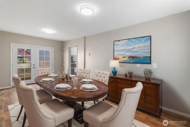 dining room with french doors, baseboards, and light wood-style floors