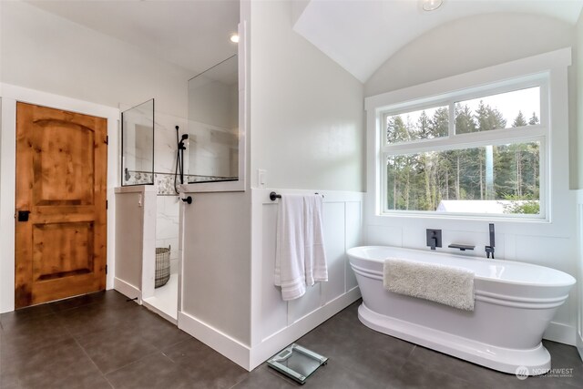 bathroom featuring a washtub and vaulted ceiling