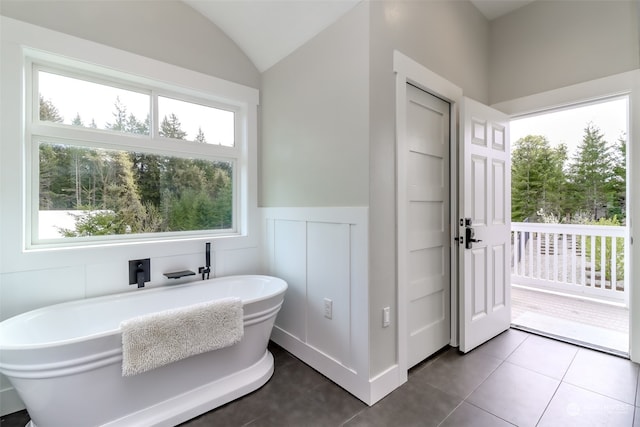 bathroom featuring a wealth of natural light, a bathtub, and tile patterned flooring